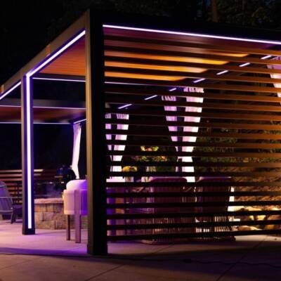Cabana with purple LED lighting and a slatted wall at night