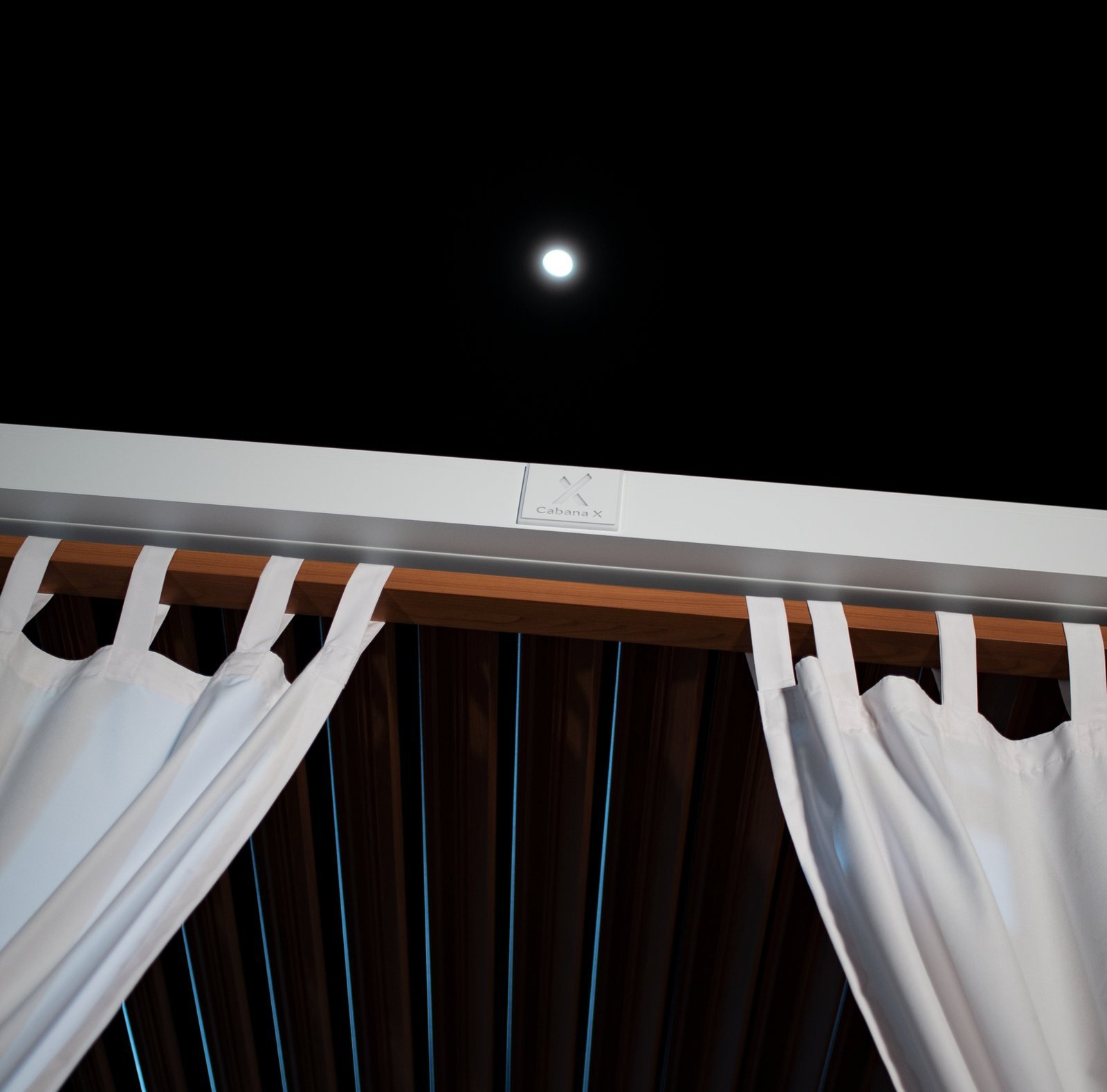 Cabana X curtains tied back under a night sky