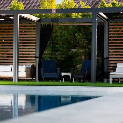 White cabana with privacy curtains beside a pool