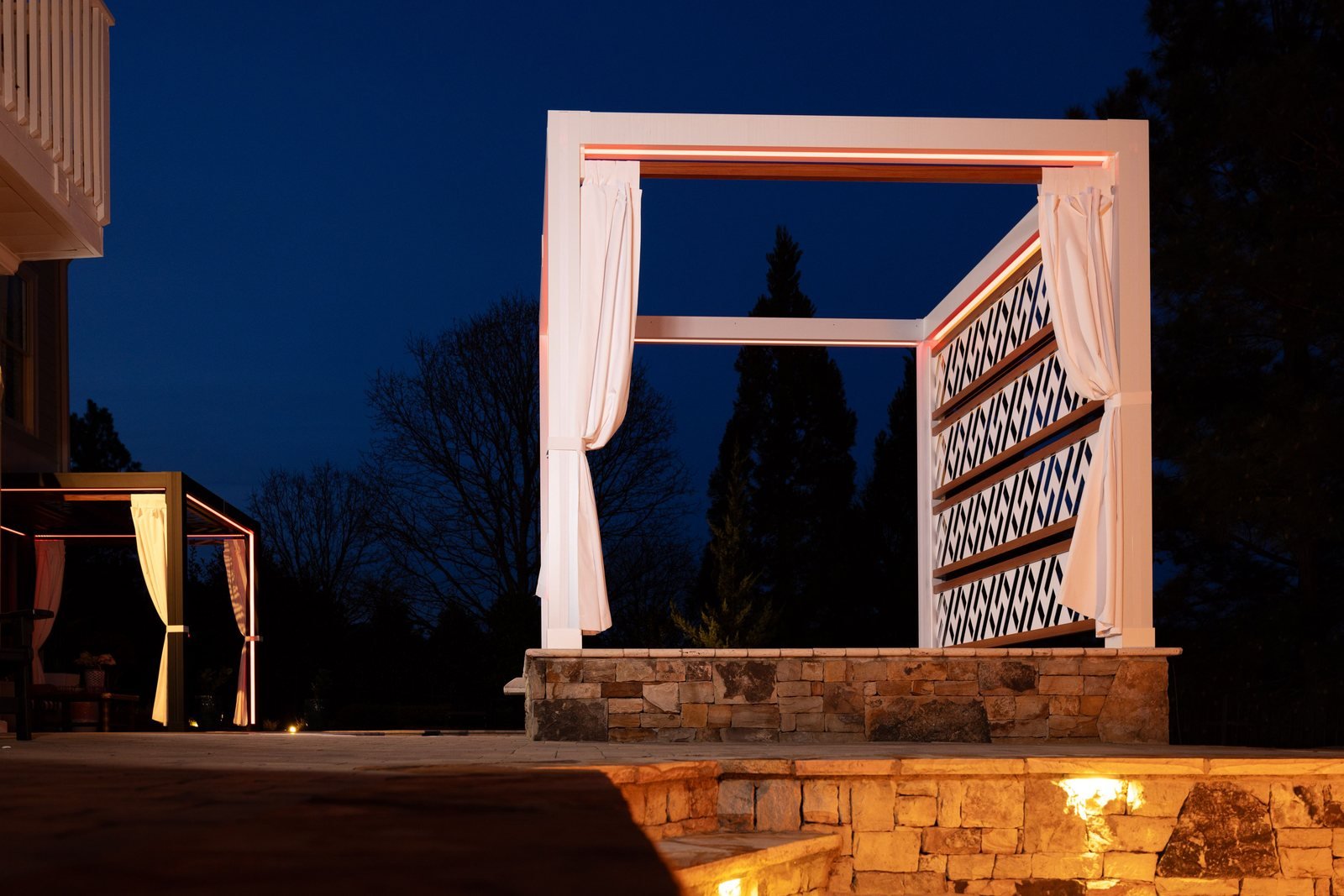 White Cabana X with a lattice privacy wall at night