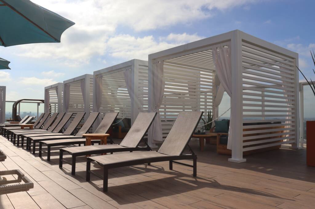 Cabana X cabanas behind loungers on a rooftop deck
