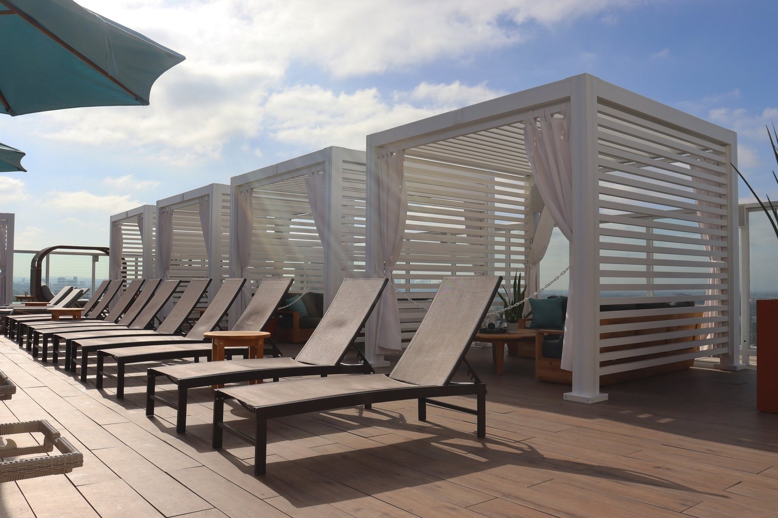 Cabana X cabanas behind loungers on a rooftop deck