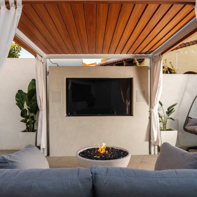 White Cabana X with curtains, a mounted TV and a fire table