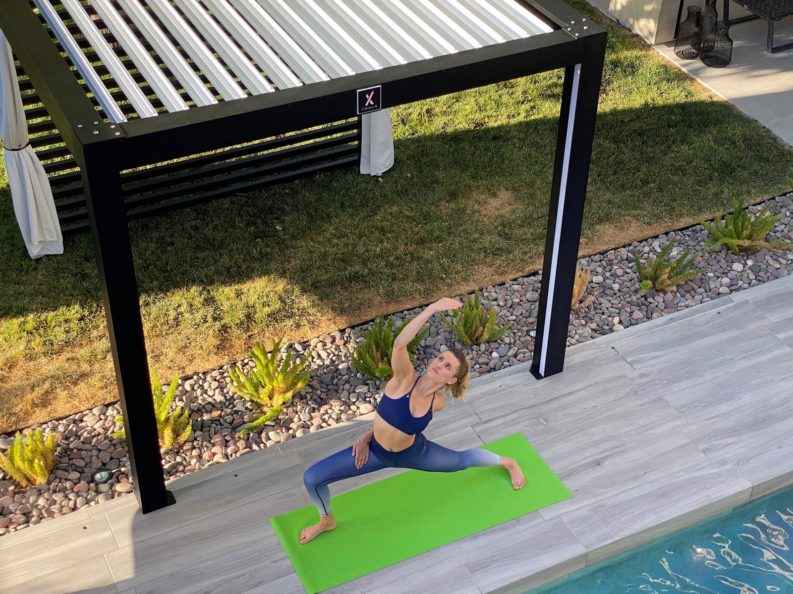 Yoga beside a pool under a black Cabana X