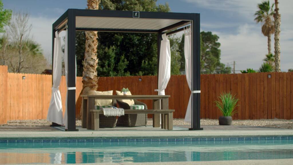 Cabana X with curtains beside a backyard pool